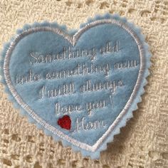 a blue heart with embroidered words on it