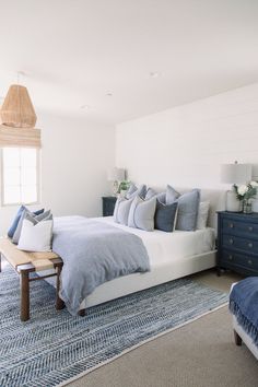 a bed with blue and white pillows in a bedroom