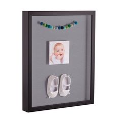 a baby's photo frame with shoes and beads