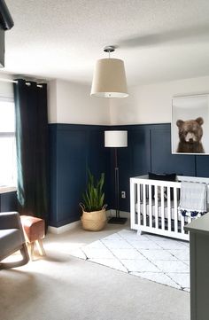 a baby's room with blue walls and white furniture