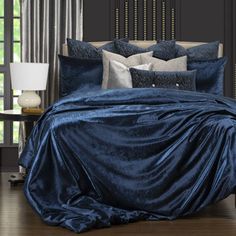 a bed covered in blue sheets and pillows