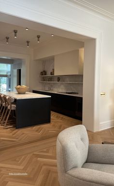 an open kitchen and dining room with wood flooring in the living room, along with modern furniture