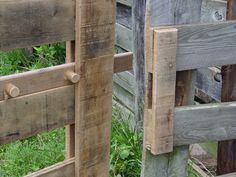 a close up of a wooden fence with grass in the background