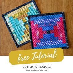 two quilted potholders sitting on top of a wooden table