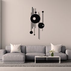 a living room with a gray couch and black clock on the wall above it's coffee table