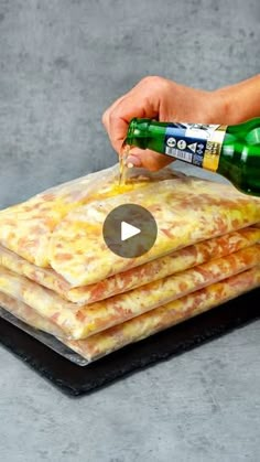 someone is pouring cheese on top of some flatbreads with a bottle of beer