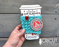 someone is holding up a cup sleeve made out of crochet