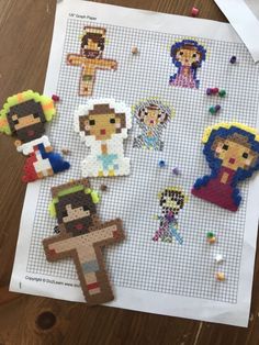 some pixelated people are sitting on top of a piece of paper with beads and thread