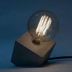 a light bulb sitting on top of a wooden block