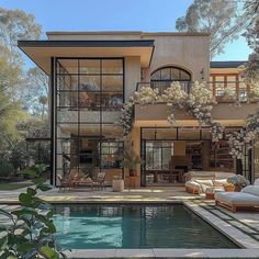 a large house with a pool in front of it and lots of windows on the side