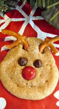 a close up of a cookie on a red and white table cloth near a christmas tree