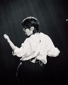 black and white photograph of a woman with her hands in the air while performing on stage