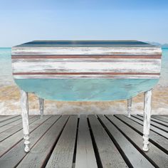 an old wooden table sitting on top of a beach