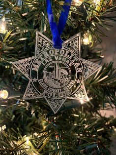 a police star ornament hanging from a christmas tree