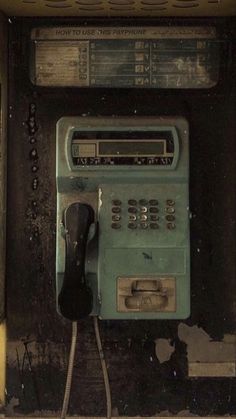 an old fashioned pay phone sitting on the side of a building