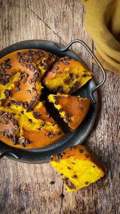 a cake with chocolate chips on top in a pan next to a piece of bread