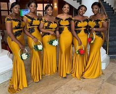 a group of women in yellow dresses standing next to each other