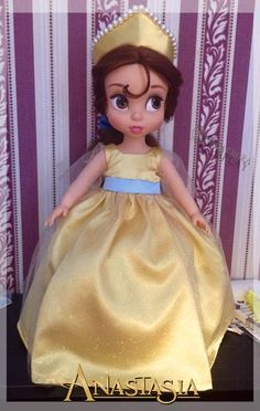 the doll is wearing a gold dress and tiara