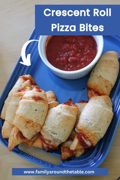 a blue tray topped with pizza bites next to a bowl of chili and dipping sauce