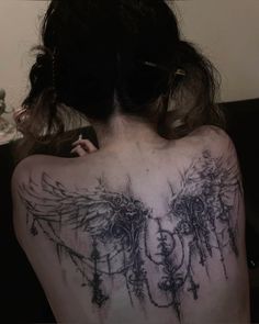 the back of a woman's shoulder with an angel tattoo on it