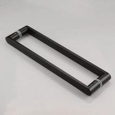 two black metal handles on a white surface with no one in the photo looking at them