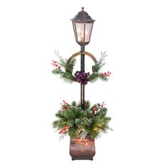 a lamp post decorated with christmas decorations and greenery for the holiday season, against a white background