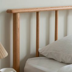 a wooden headboard in a bedroom next to a lamp