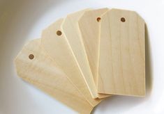 four unfinished wooden tags on a white plate