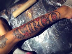 a man with a tattoo on his arm that says arrigo and has flowers in it