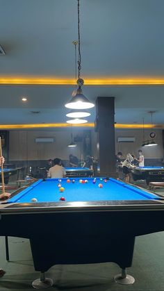 a pool table in a room with people playing billiards