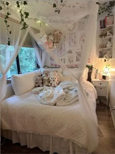 a white bed with lots of pillows and stuffed animals on it's headboard