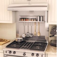 a stove top oven sitting in a kitchen next to a counter with utensils on it