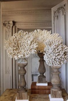 two vases filled with white flowers on top of a table