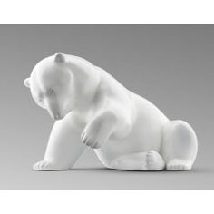 a white bear figurine sitting on the ground