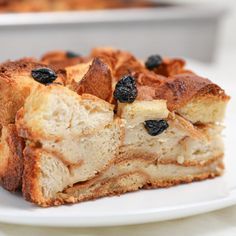 a piece of bread with raisins and blueberries is on a white plate