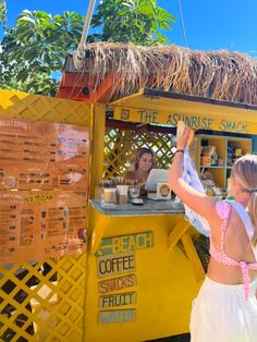 a woman standing in front of a food cart