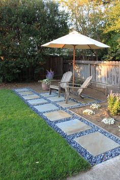 a patio with chairs and an umbrella in the grass next to a fenced in area