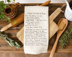 an old recipe paper with writing on it next to wooden utensils and herbs