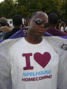 a man wearing a white t - shirt that says i love spellhouse and has a heart on it