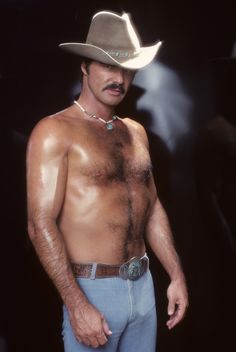 a man with no shirt wearing a cowboy hat