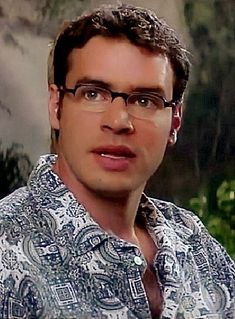 a man wearing glasses and a shirt with an elephant on it's chest is looking at the camera