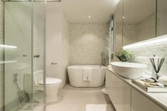 a bathroom with a tub, sink and toilet next to a walk - in shower