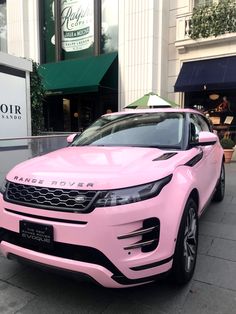 a pink land rover parked in front of a building