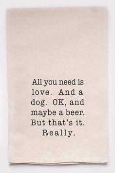 a tea towel with the quote all you need is love and a dog ok and maybe a beer but that's it really really