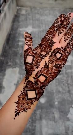 a woman's hand with henna tattoos on it