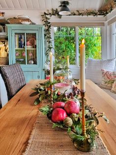 a wooden table topped with apples and candles