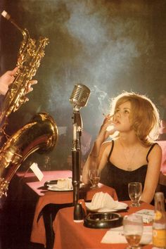 a woman sitting at a table with a saxophone in front of her