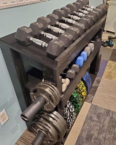 a gym equipment rack with dumbs and plates