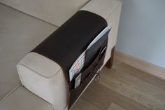 a white couch with magazine holders on it's back and the seat upholstered