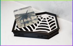 a black and white spider web on a tray with a soap dish in the shape of a rectangle